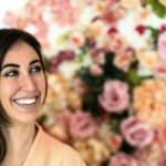 Ritratto Dottoressa Medicina Estetica: Sorridente con Sfondo Floreale Colorato