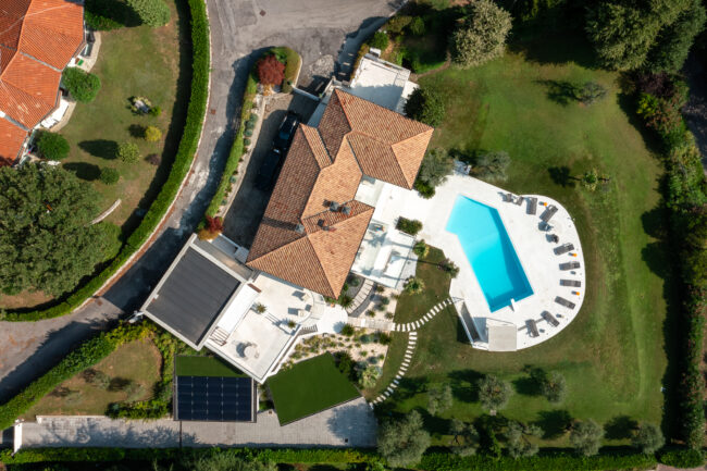 Vista Aerea con Drone di una Villa con Piscina a Garda, Un'Inquadratura dall'Alto che Rivelà la Bellezza Architettonica e il Fascino del Paesaggio Circostante.