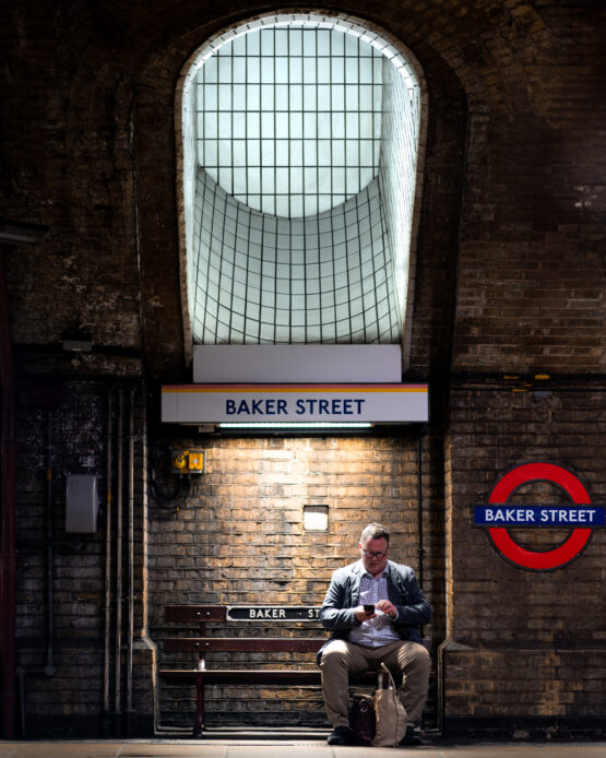 Uomo Seduto su Panchina alla Stazione Metro di Baker Street, Londra
