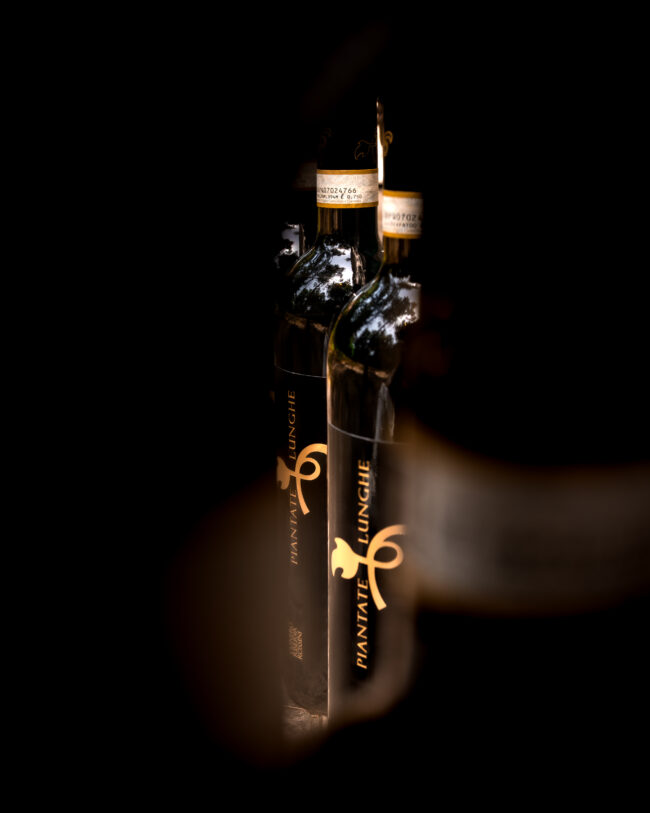 Bottiglie Viste Attraverso Altre Due, Mettendo in Risalto con Eleganza il Brand dell'Azienda, un Dettaglio che Esprime Stile e Riconoscibilità.