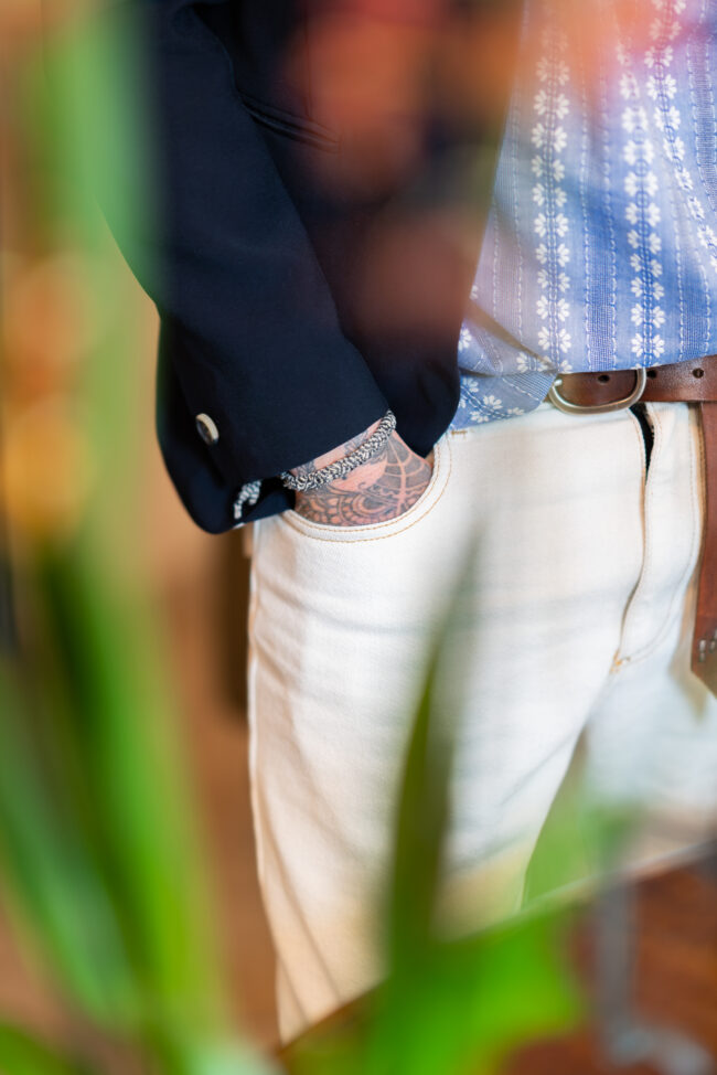 Dettaglio di Capi di Abbigliamento Visto Attraverso una Pianta Sfocata, Un'Inquadratura Che Mette in Risalto la Bellezza e lo Stile con un Tocco di Raffinata Sfocatura.