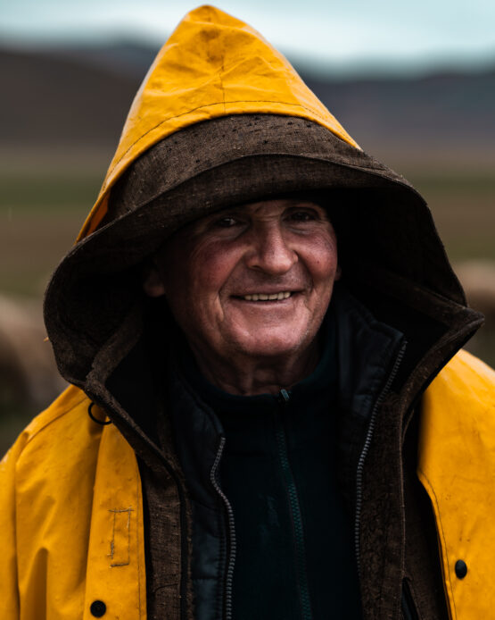 Ritratto di un pastore con impermeabile giallo durante una giornata uggiosa a Castelluccio.