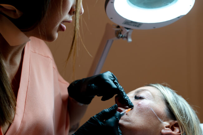 Dottoressa di Medicina Estetica: Momento di Trattamento, Dettaglio della Dottoressa che Inietta Botox con una Siringa su una Paziente, Rappresentando Competenza e Cura Estetica.