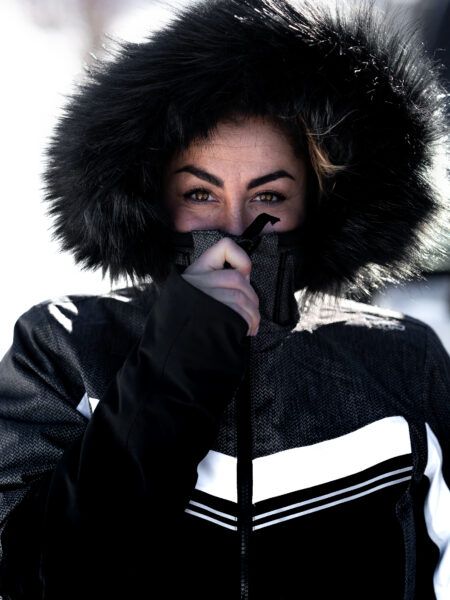 Occhi Espressivi di una Ragazza, Avvolta nel Calore di una Pelliccia con Cappuccio, Un Dettaglio Che Riflette Forza e Eleganza.