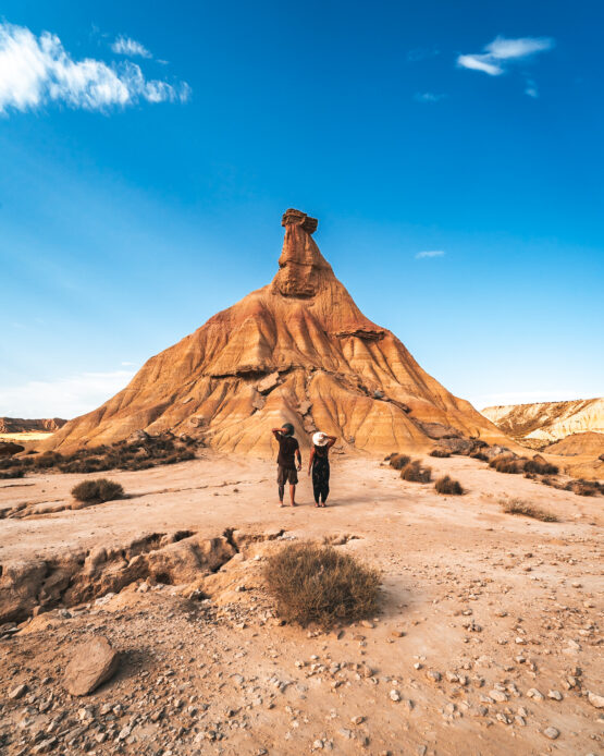 Coppia Girata di Spalle di Fronte al Maestoso Castildetierra a Bardenas Reales: Un'Immagine di Intimità Contemplativa di Fronte a un Paesaggio Iconico.