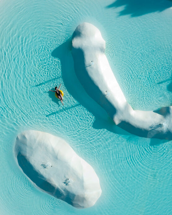 Aria Estiva: Vista Aerea con Drone in una Piscina, Una Ragazza Rilassata Distesa con un Gonfiabile Giallo, Catturando la Gioia e la Spensieratezza Estiva.