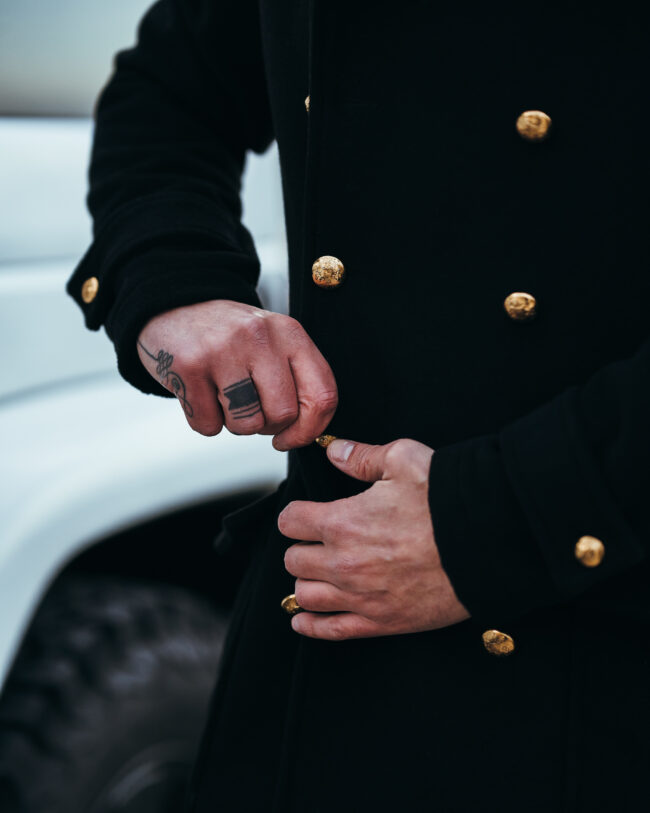 Mani con Precisione Chiudono i Bottoni di un Elegante Cappotto napoleonico.