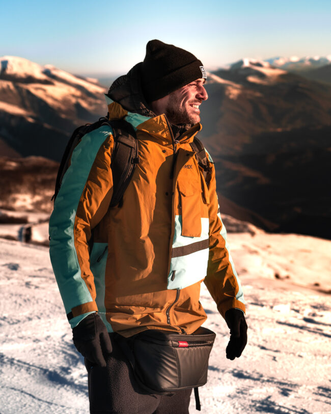 Ritratto di ragazzo in montagna al tramonto, indossa abbigliamento di vari brand sponsorizzati per un lavoro.